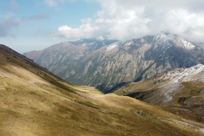 قمم جبلية مغطاة بالثلج والغيوم من أعلى منتجع شيمبولاك قرب ألماتي